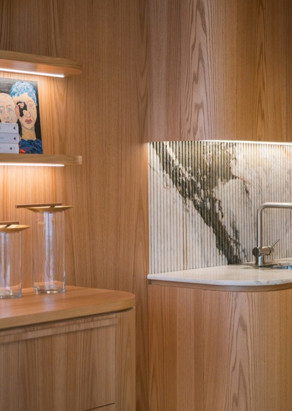 Holzvertäfelte Teeküche in Esche mit Marmorrückwand.