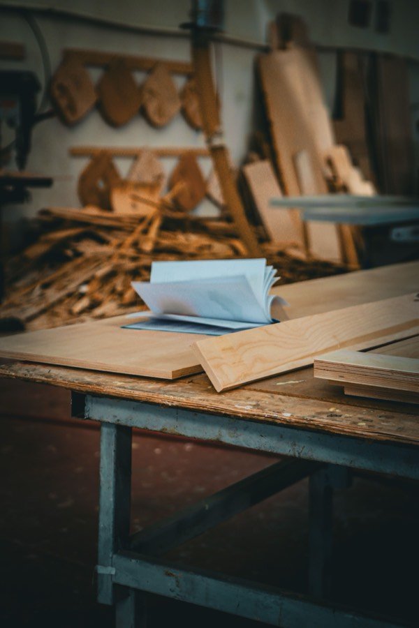Zugeschnittene Holzplatten und Leisten auf einer Werkbank.